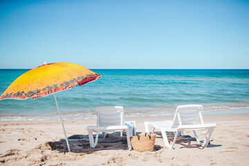 Beach sun beds and umbrella on white beach