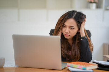 Asian women are stressed while working on laptops, Tired Asian businesswomen with headaches at the office, feel sick at work, and copy space.