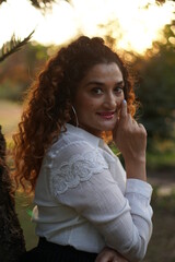 girl with curly hair posing in golden light