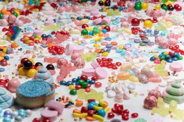 CMulti-colored candy balls on icing sugar table. Candy sweets background made of assorted chocolate...
