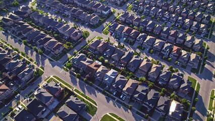 Aerial view of American suburban neighbourhood. Residential single American family houses. North America suburb streets. Established Real estate at golden hour sunset with long shadows.