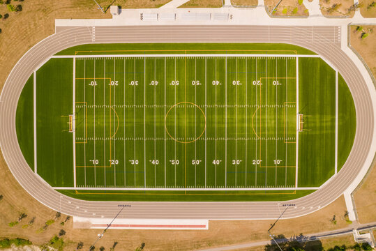 Top view of empty soccer field without players. Football field with grass and white paint lines and marks. Sports soccer and football with green surface. Recreational activity.