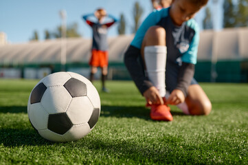 Obraz na płótnie Canvas Soccer ball on grass and children football team training