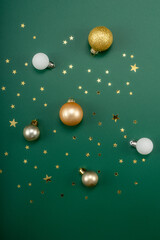 Christmas composition. Christmas ball and stars on green background.