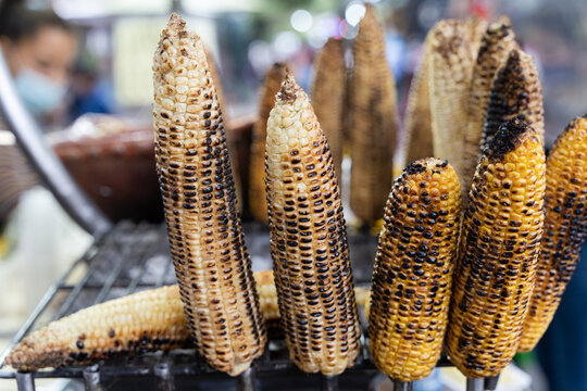 Corn on the cob grilled at street market in Mexico. Cheap healthy food, burnt concepts