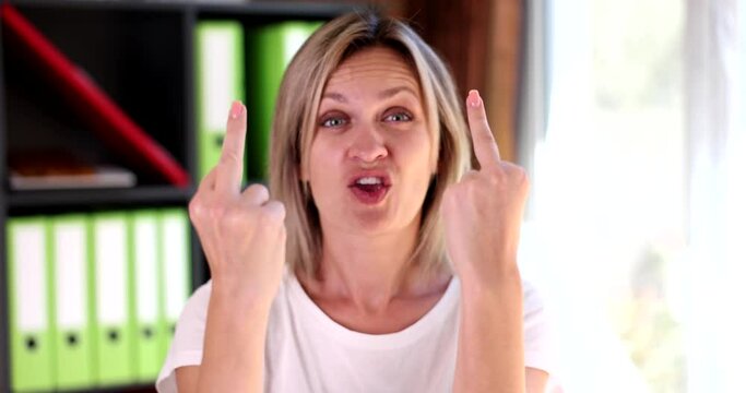 Portrait of beautiful angry aggressive woman showing gesture of fuck you