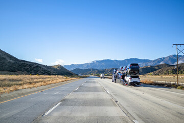Industrial standard car hauler big rig semi truck transporting cars on the two level semi trailer...