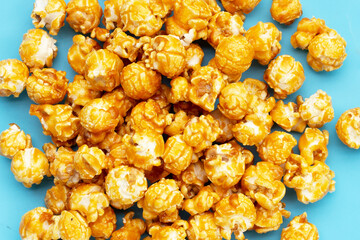 Honey caramel popcorn on blue background.