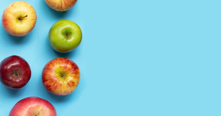 Various types of apples on blue background.
