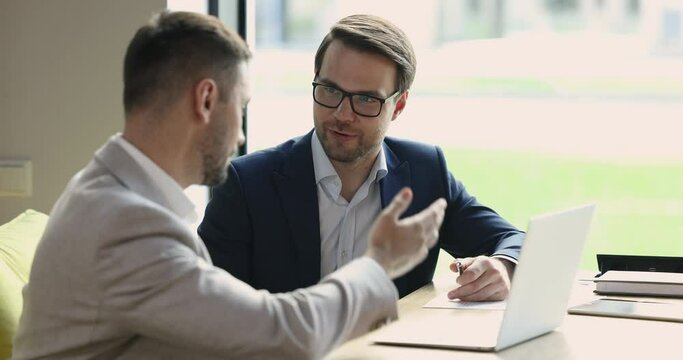 Two young, ambitious business partners making profitable commercial deal, shake hands, finish formal meeting in company office, express respect, showing recognition. Cooperation, investment, business