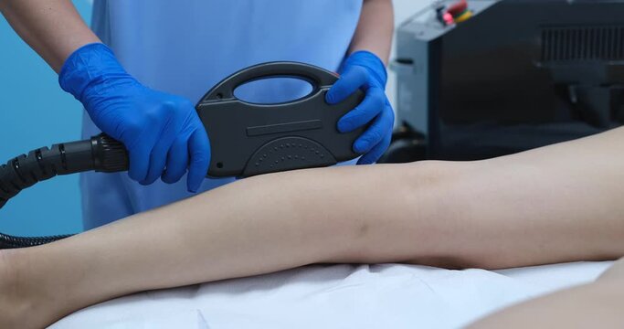 Woman having laser epilation of legs in professional beauty salon