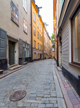 Narrow alley in Gamla stan, the old town of Stockholm, Sweden, with old style orange colored houses and cobblestone street, Stockholm, Sweden