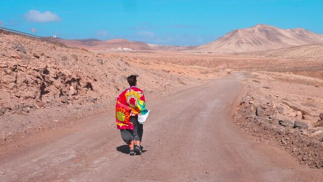 nature, beauty - young tourist walks on the volcanic red earth of Fuerteventura 