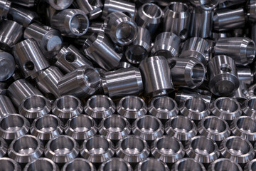 Cylindrical metal parts stacked in a row.