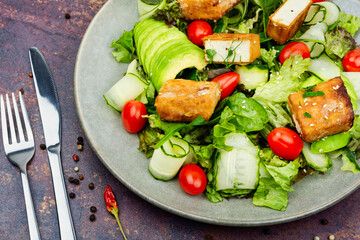 Healthy salad of frying tofu cheese and fresh vegetables.