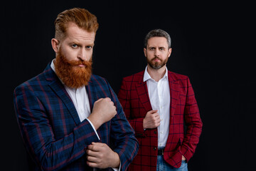 unshaven elegant men wearing formalwear. studio shot of two men in formalwear jackets.