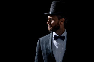 photo of tuxedo presenter in cylinder hat. tuxedo presenter isolated on black background.