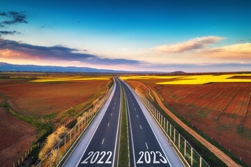 Aerial view of highway on 2022 year sunset and new year 2023. Transportation, logistic and...