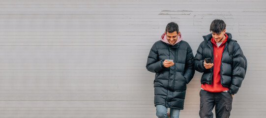 young people on the street with mobile phone in winter with warm clothes