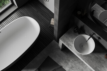 Top view of grey bathroom interior with sink and tub with accessories