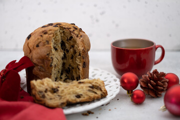 Chocolate-chips Panettone and cup of tea on white table with festive decorations. High quality photo