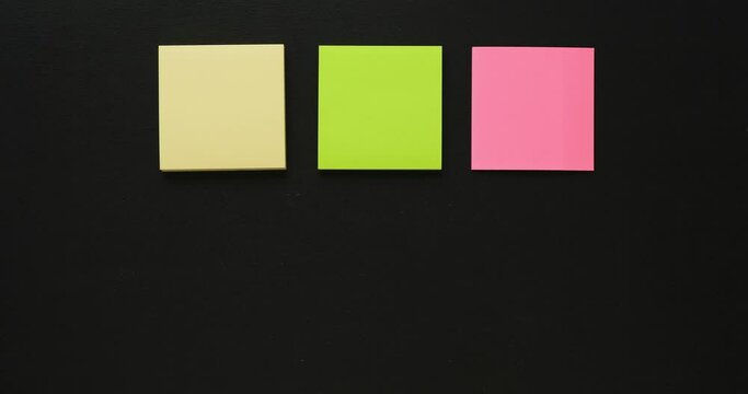 Six multi-colored stacks of note paper on a black background. Looped 4K stop motion animation