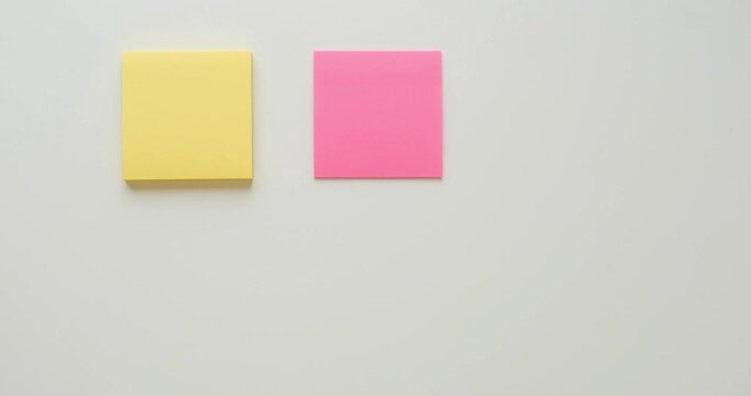 Six multi-colored stacks of note paper on a white background. Looped 4K stop motion animation