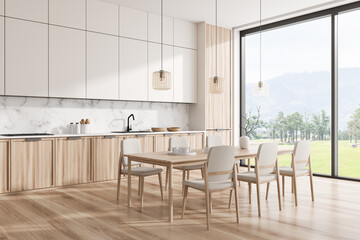 Stylish kitchen interior with dining table and cooking zone, panoramic window