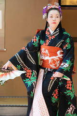 着物姿で扇子を持って日本舞踊を踊る若い日本人女性