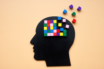 A head with colored cubes, part of which is lost as a symbol of dementia.