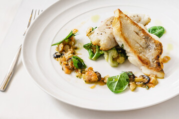 fish with vegetables on the white plate
