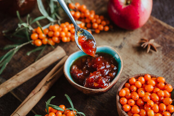apple and sea buckthorn jam in a jar, fresh berries and fruits, spicy spices of cinnamon and anise on a brown wooden background 2