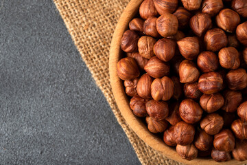 Top view of a bowl full of hazelnuts on dark background
