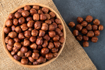 Top view of a bowl full of hazelnuts on dark background
