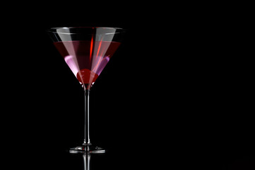 Pink cocktail with cherry in martini glass