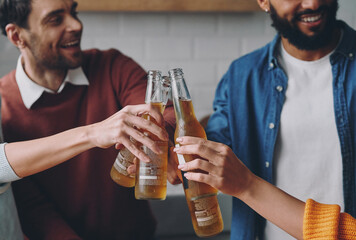 Close-up of happy young people toasting with beer while spending fun time together