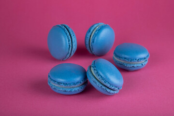 Obraz na płótnie Canvas Closeup of macaroon cakes in blue on red background
