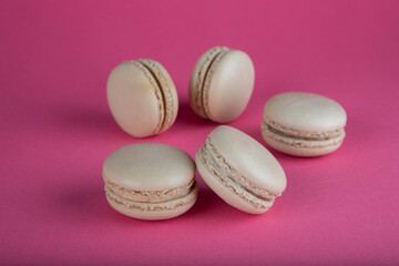 Closeup of beige macaroon cakes on red background