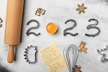 The inscription 2023 on flour on a kitchen board for working with dough.