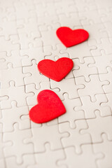 red hearts shapes on blank white jigsaw puzzle