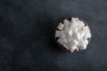 White sugar cubes in bowl on a black background