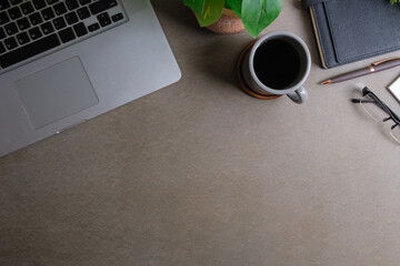 Top view of laptop computer, coffee cup, notebook and potted plant. Copy space for your text..