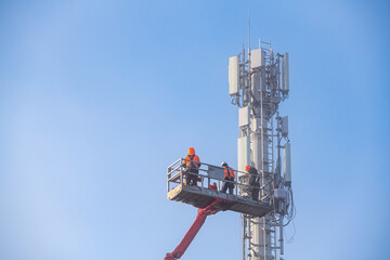 Déploiement du réseau 5G. Pose d'antennes sur un mat de téléphonie mobile dans la brume hivernale - obrazy, fototapety, plakaty