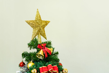 Closeup of woman's hand decorating Christmas tree Christmas gift wrapping with red bow Christmas tree with lights and a gift box in the festive decoration room close up Merry Christmas