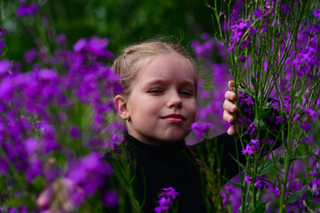 A girl with long hair, walking in the field. A lot of purple flowers Ivan tea. Photo shoot in nature.