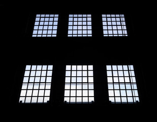 Windows in an old building with blue sky seen through windows