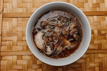 Udon soup with shrimps on a wooden tray. View from above.