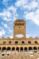 Close up on the Volognana tower, in the façade of Palazzo Vecchio with Florentine red lily and...