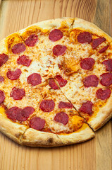 classic traditional dish pepperoni pizza with sausage Italian cuisine on a wooden background