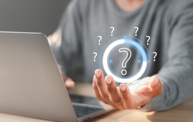 Businessman with question mark on virtual screen. Question marks concept.